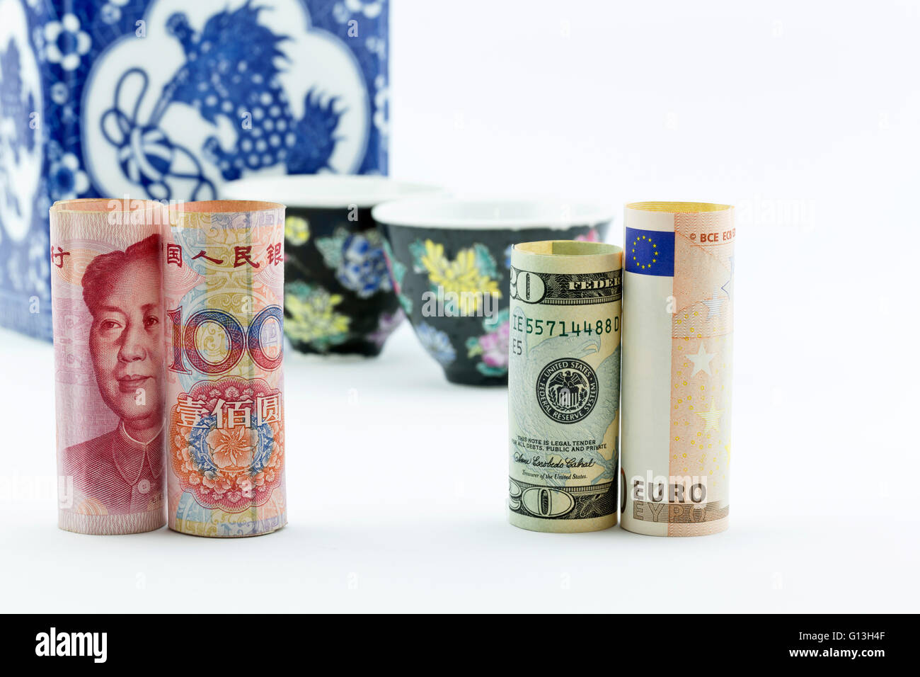 Chinesische Yuan Währung, amerikanisches Geld und Europäische Union Euro stehen vor asiatische Porzellan Teetassen und Vorratsgefäß Stockfoto