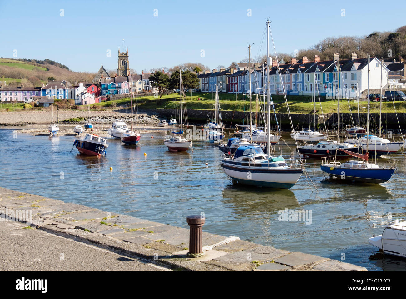 Blick entlang Afon Aeron Flussmündung zur Kirche mit Boote vertäut im Hafen auf einer Flut in Küstenstadt. Aberaeron Wales Stockfoto