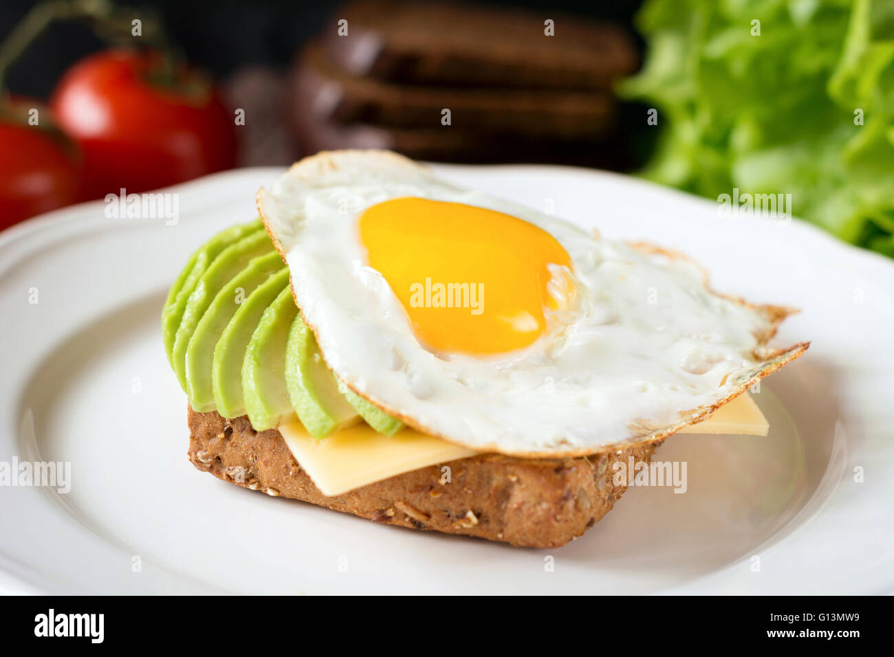 Sonnenseite, Ei, Avocado und Käse auf Vollkorn Toast für gesundes Frühstück Stockfoto