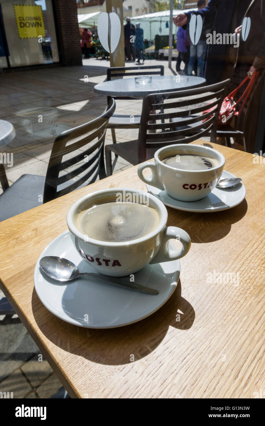 Zwei Tassen Kaffee auf einem Tisch in einem Zweig der Costa.  Zeigen das Costa-Logo auf den Cups. Das Unternehmen ist im Besitz von Whitbread. Stockfoto