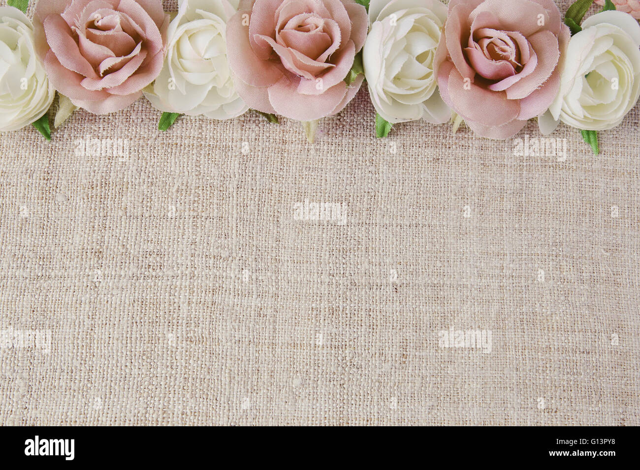 Rosa weiße rose Kunstblumen auf Leinen, Kopie, Raum Hintergrund, Tiefenschärfe, Vintage-Ton Stockfoto