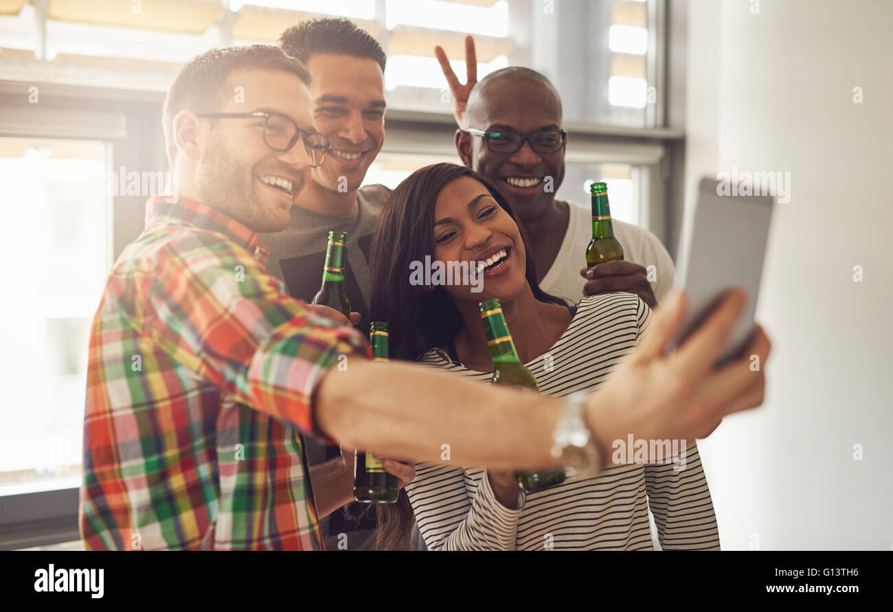 Freunde bei der Arbeit dabei, dass Selbstporträt mit Kamera-Handy mit grünem Glasflaschen Bier im Büro-Partei Stockfoto