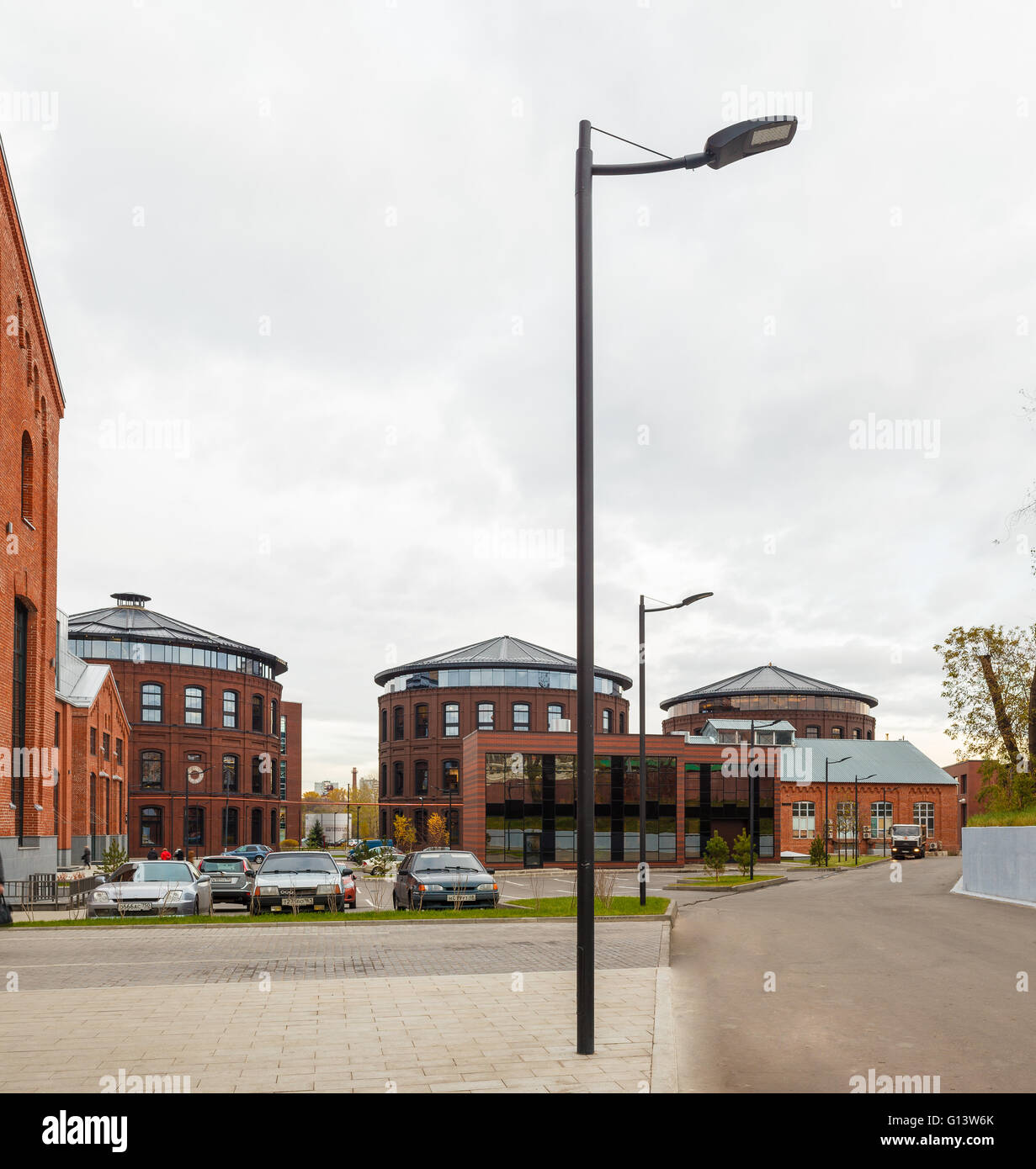 Umfangreiche Büro komplexe Exterieur im Loftstil. Rote Backsteinbauten der ehemaligen Fabrik, Gasbehälter. Am Abend Architektur vo Stockfoto