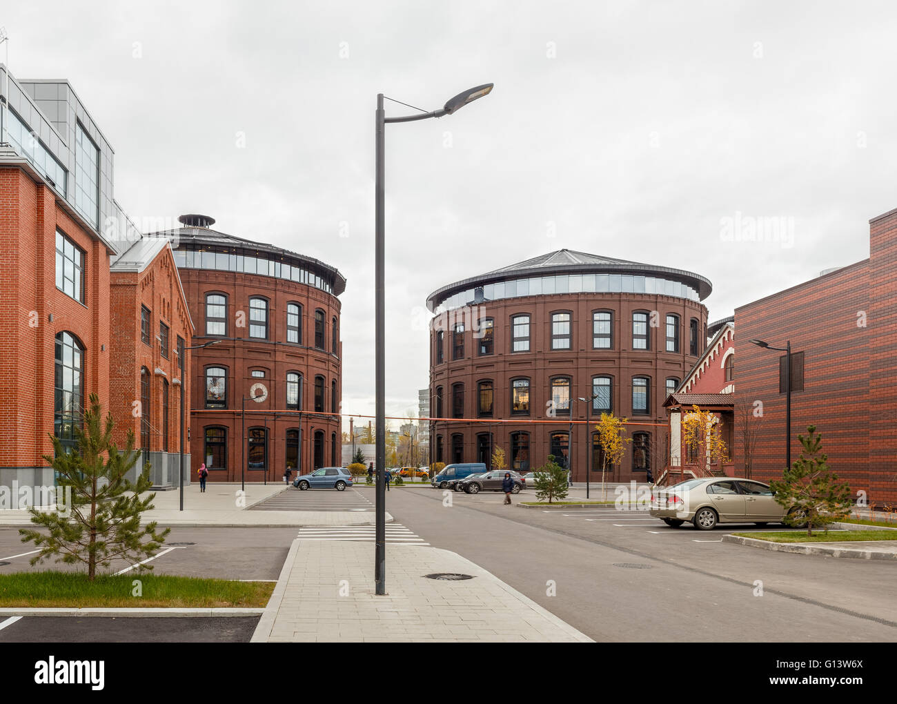 Umfangreiche Büro komplexe Exterieur im Loftstil. Rote Backsteinbauten der ehemaligen Fabrik, Gasbehälter. Am Abend Architektur vo Stockfoto