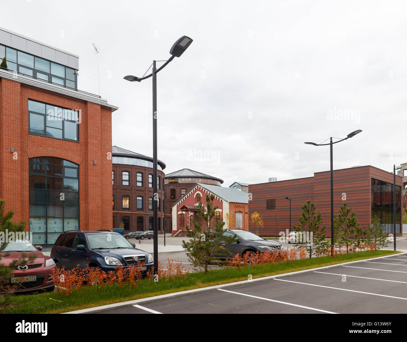 Umfangreiche Büro komplexe Exterieur im Loftstil. Rote Backsteinbauten der ehemaligen Fabrik, Gasbehälter. Am Abend Architektur vo Stockfoto
