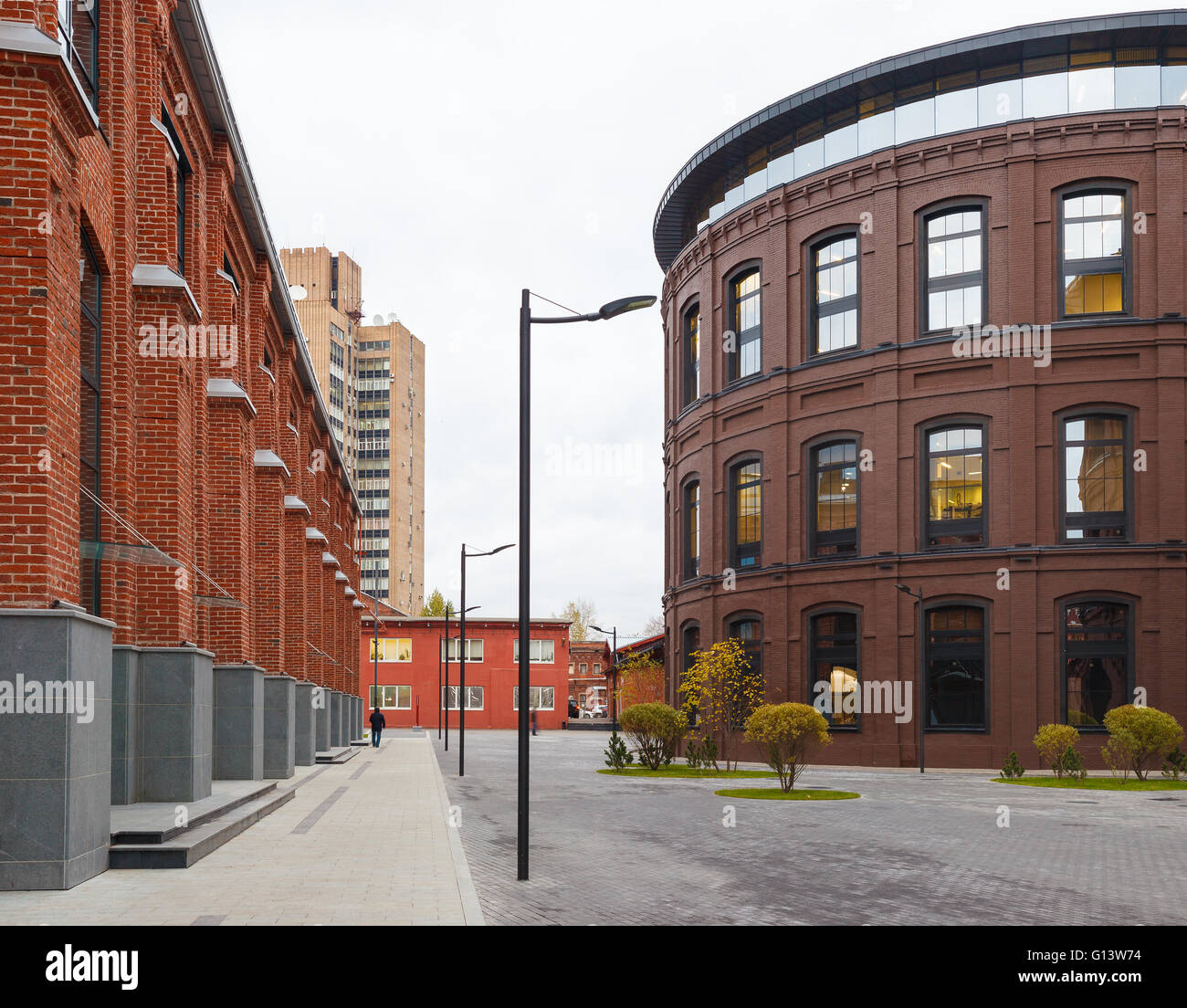 Umfangreiche Büro komplexe Exterieur im Loftstil. Rote Backsteinbauten der ehemaligen Fabrik, Gasbehälter. Am Abend Architektur vo Stockfoto