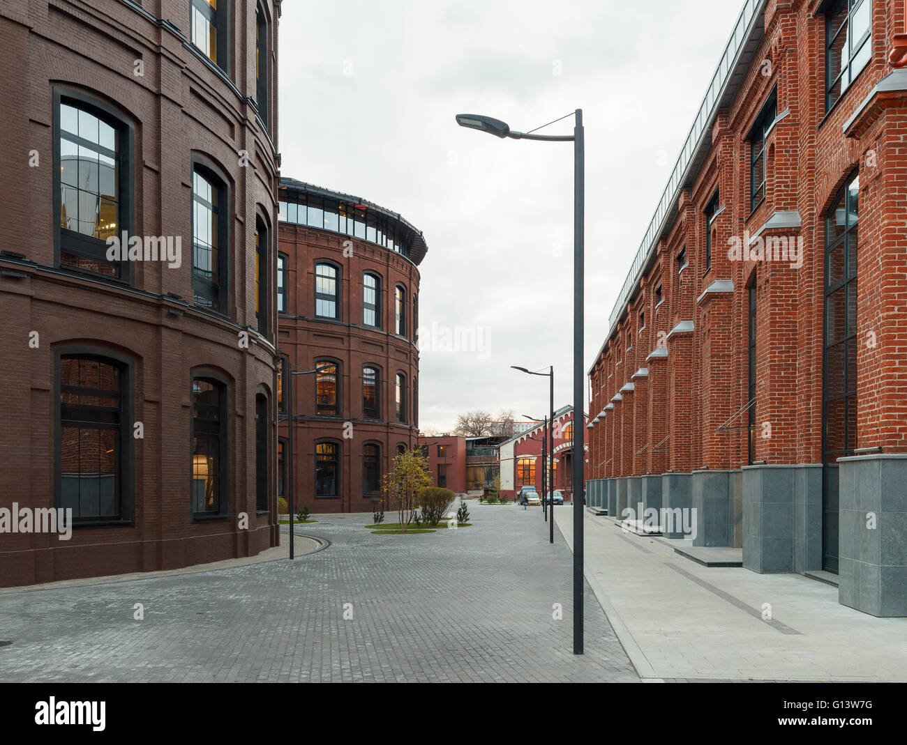 Umfangreiche Büro komplexe Exterieur im Loftstil. Rote Backsteinbauten der ehemaligen Fabrik, Gasbehälter. Am Abend Architektur vo Stockfoto