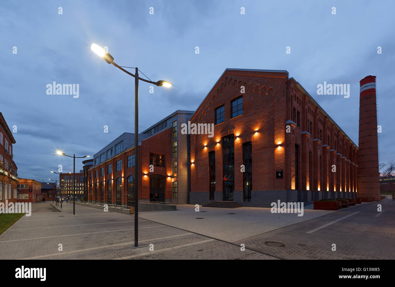 Umfangreiche Büro komplexe Exterieur im Loftstil. Rote Backsteinbauten der ehemaligen Fabrik, Gasbehälter. Am Abend Architektur vo Stockfoto