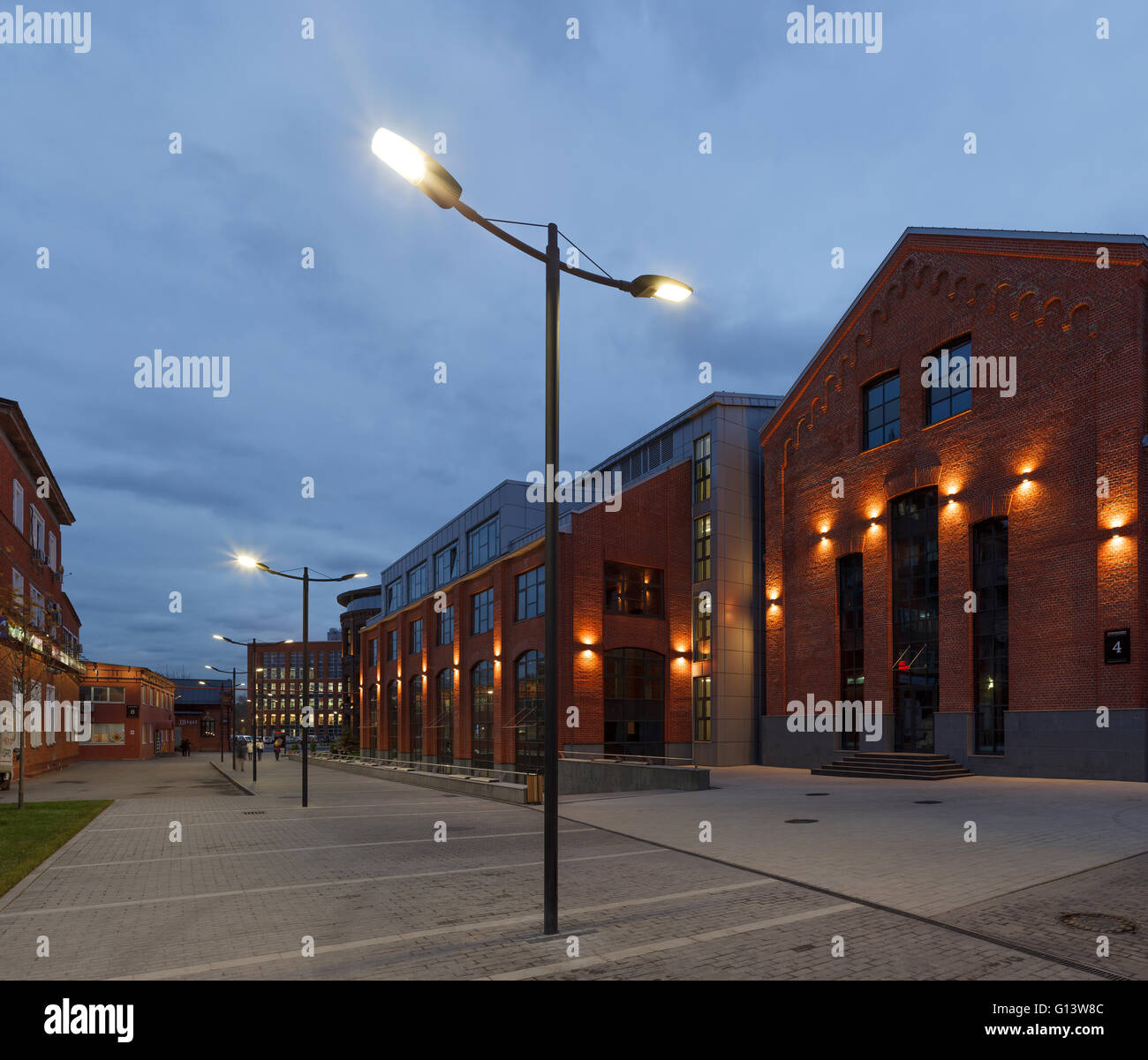 Umfangreiche Büro komplexe Exterieur im Loftstil. Rote Backsteinbauten der ehemaligen Fabrik, Gasbehälter. Am Abend Architektur vo Stockfoto