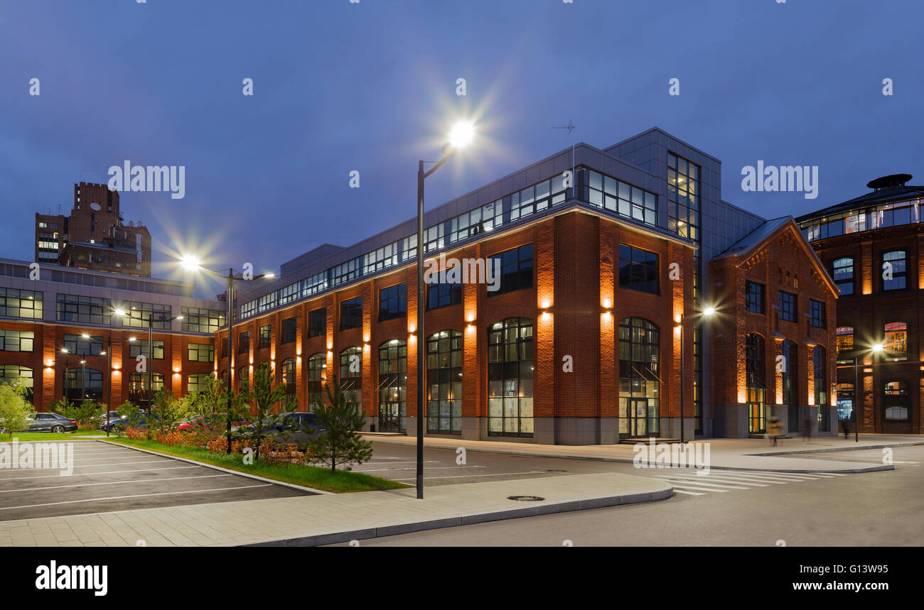 Umfangreiche Büro komplexe Exterieur im Loftstil. Rote Backsteinbauten der ehemaligen Fabrik, Gasbehälter. Am Abend Architektur vo Stockfoto