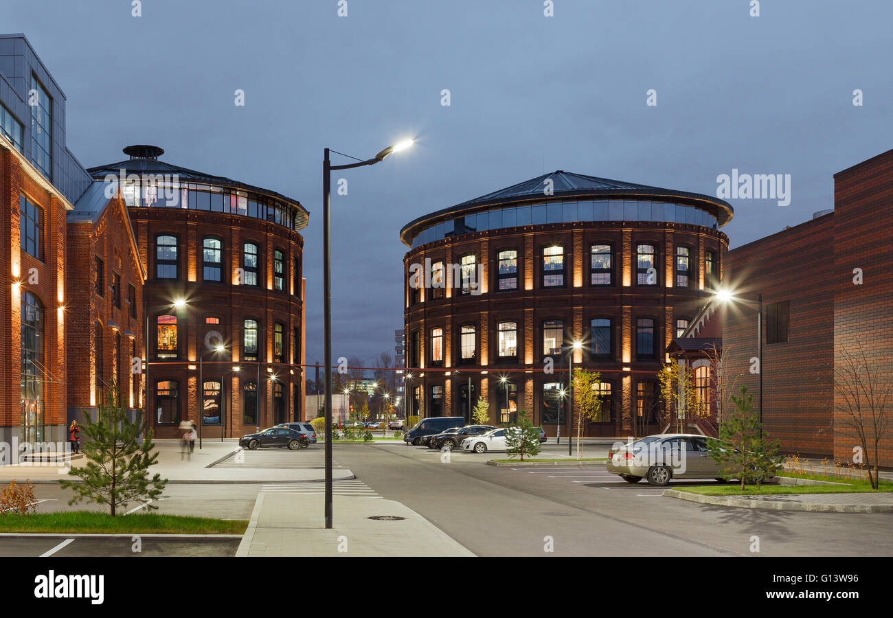 Umfangreiche Büro komplexe Exterieur im Loftstil. Rote Backsteinbauten der ehemaligen Fabrik, Gasbehälter. Am Abend Architektur vo Stockfoto