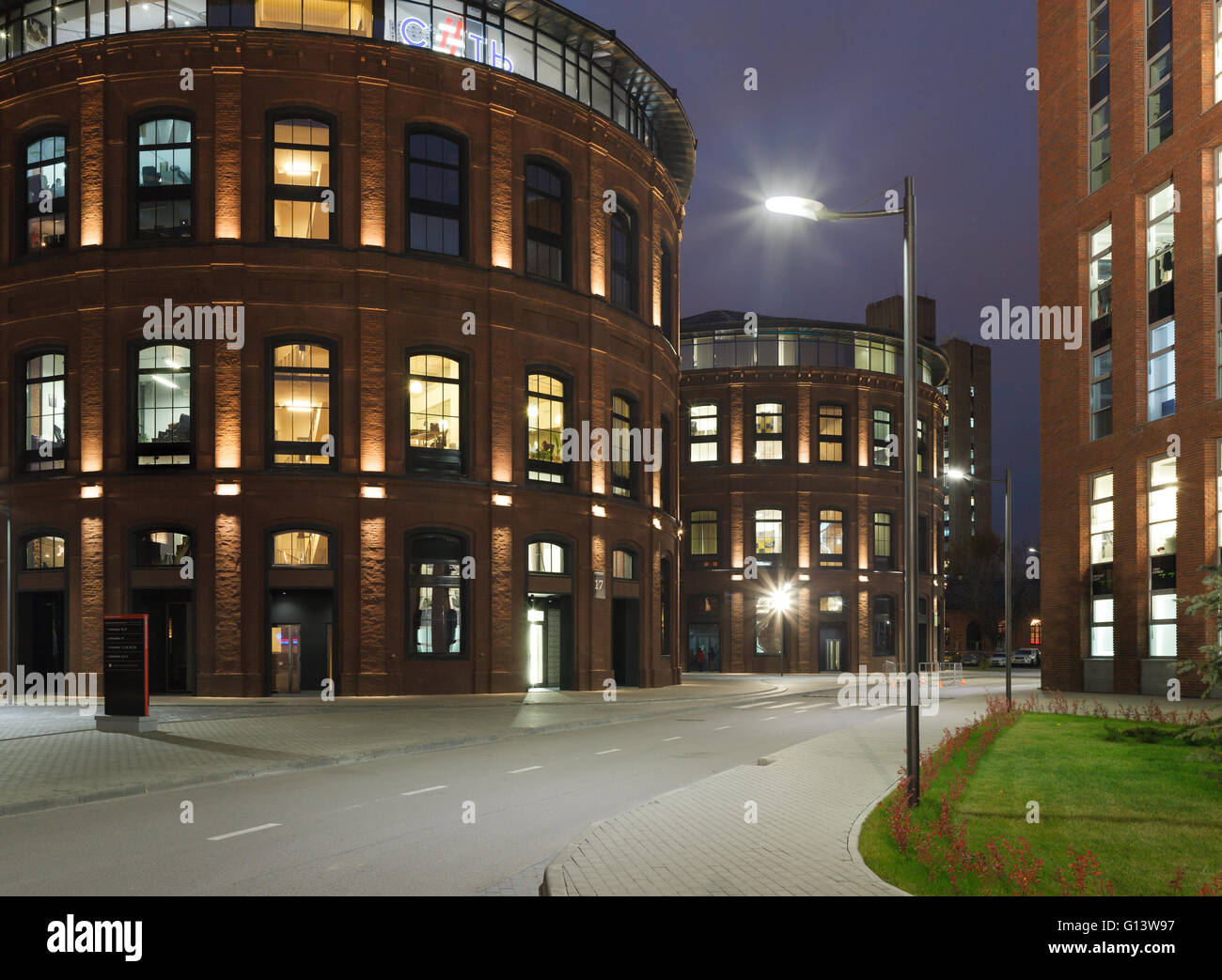 Umfangreiche Büro komplexe Exterieur im Loftstil. Rote Backsteinbauten der ehemaligen Fabrik, Gasbehälter. Am Abend Architektur vo Stockfoto