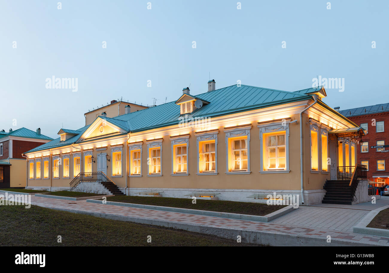 Ein einstöckiges Gebäude im klassischen Palladio-Stil mit gelben Wänden und abends Architekturbeleuchtung. Moskau, Russland Stockfoto