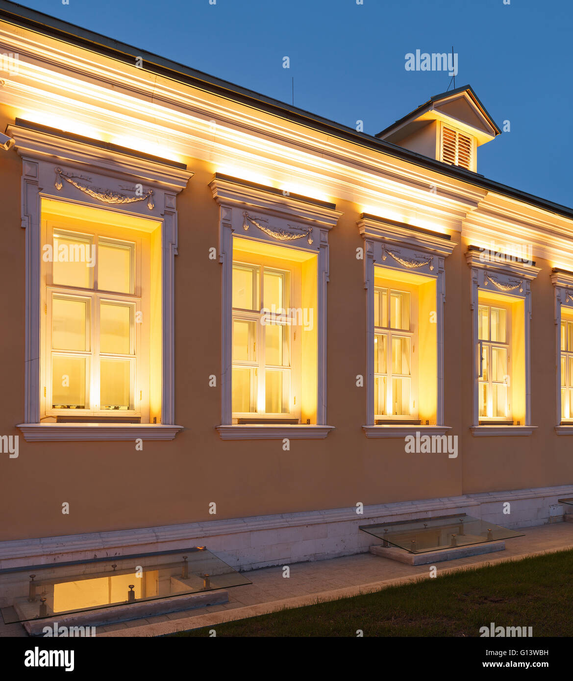 Ein einstöckiges Gebäude im klassischen Palladio-Stil mit gelben Wänden und abends Architekturbeleuchtung. Moskau, Russland Stockfoto