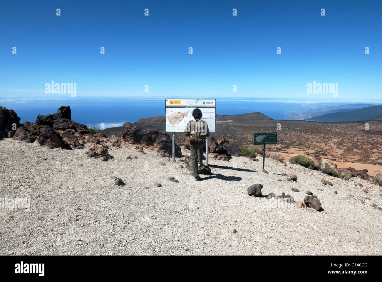 Ein junger Wanderer prüft das informative Panel im Montaña Blanca, am Fuße des El Teide, in den Cañadas. Teneriffa, Kanarische Inseln Stockfoto