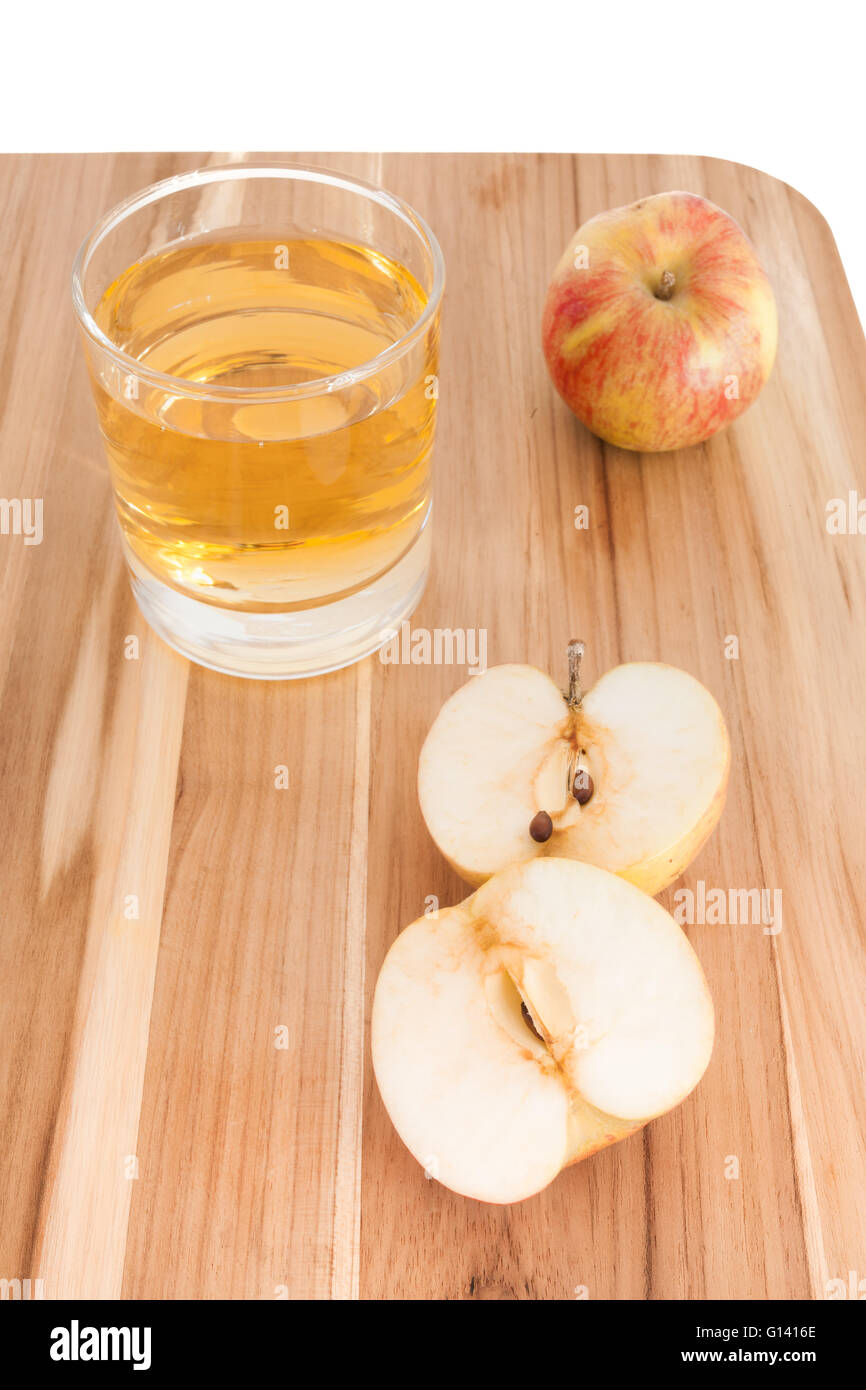 In Scheiben geschnitten und ganzen Apfel auf Schneidebrett mit Glas Apfelsaft Stockfoto