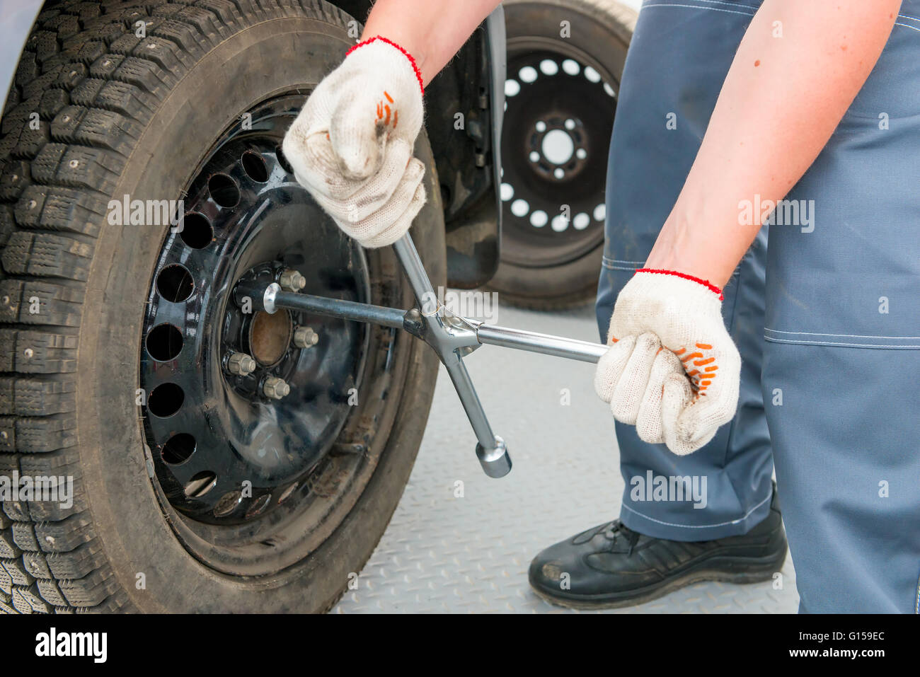 Mechaniker schraubt die Muttern auf dem Rad einen Schraubenschlüssel Stockfoto
