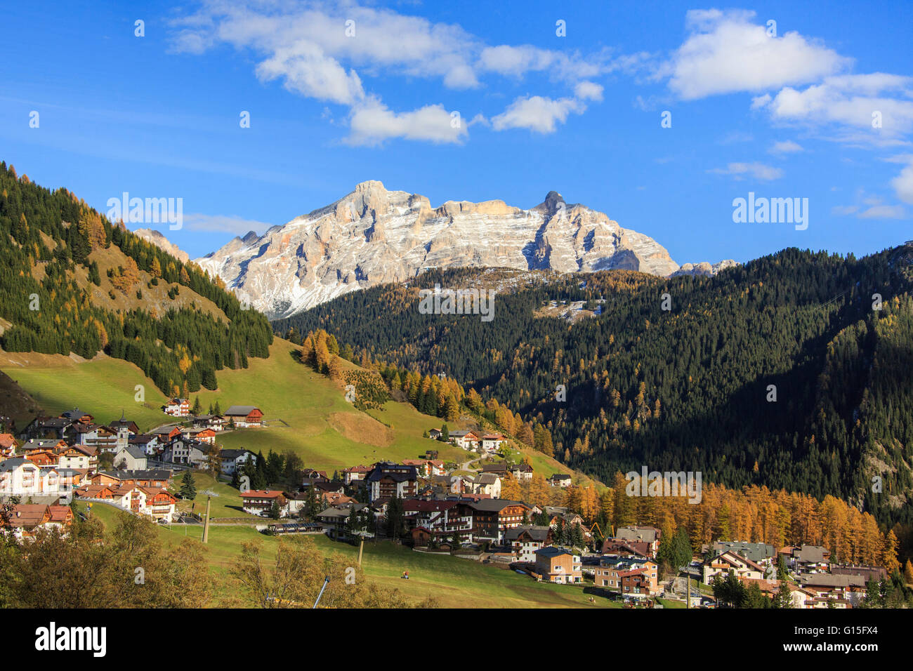 Bunte Wälder umrahmen das Dorf und den hohen Gipfeln im Herbst, Grödner Joch, Südtirol, Trentino-Alto Adige, Italien, Europa Stockfoto