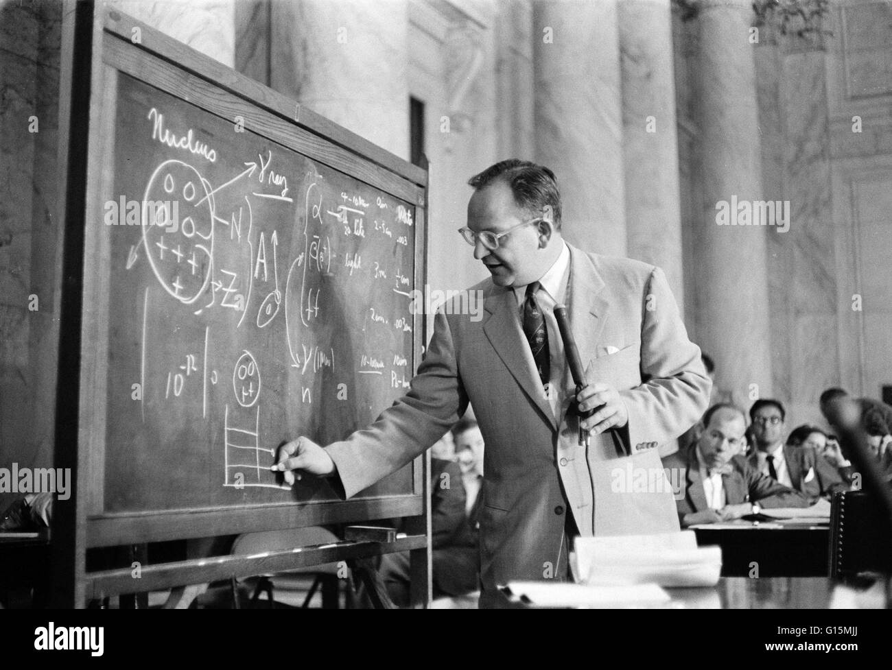 Mills zeichnen Diagramme auf einer Tafel im Zeugnis vor der gemeinsamen Atomenergie Kongressausschuss Anhörungen auf atomare radioaktiven Fallout. 27. Mai 1957. Mark Muir Mühlen (8. August 1917-7. April 1958) war ein US-amerikanischer Kernphysiker und de Stockfoto
