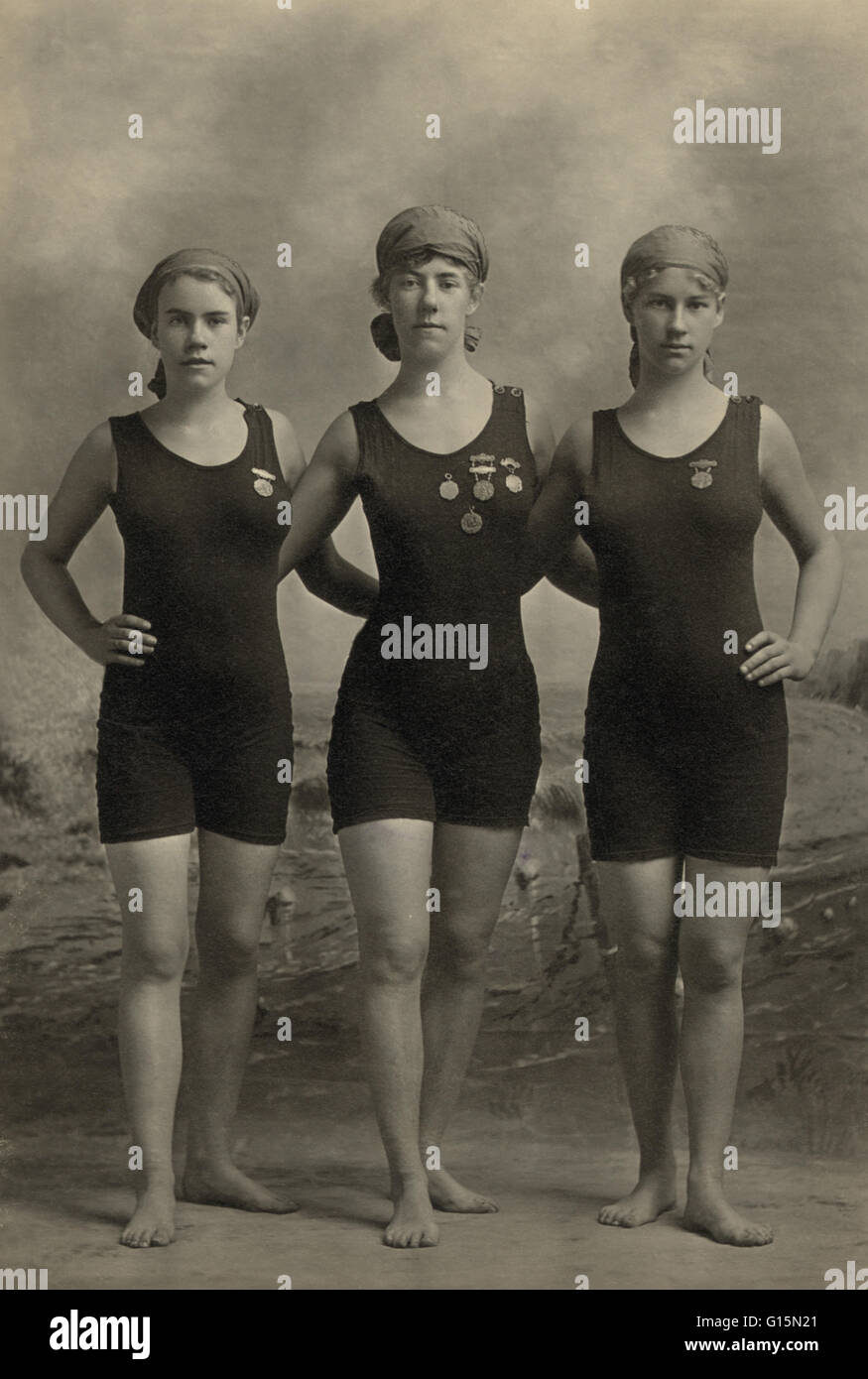 Drei junge Frauen posieren in Badeanzügen und tragen ihre schwimmen Konkurrenz Medaillen, 20er Jahre. Modegeschichte war in das 20. Jahrhundert mit einigen schockiert von den neueren Gliedmaßen alle freizügigen Figur umarmt Badeanzüge, die den Körper enthüllt deutlicher als eve Stockfoto