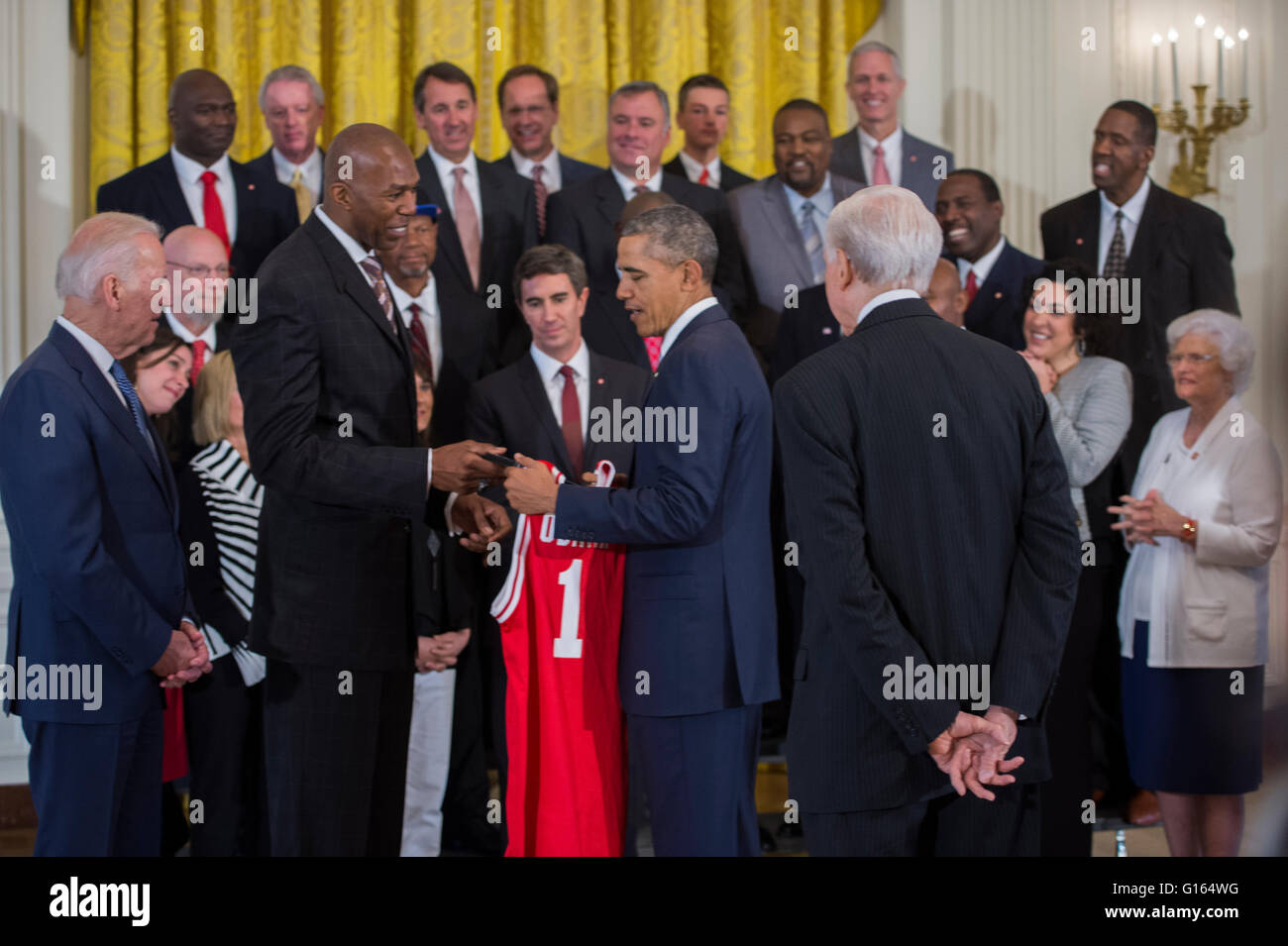 Washington, DC, USA. 9. Mai 2016. US-Präsident Barack Obama, mit Vizepräsident Joseph Biden (L) erhält eine Trikot von Thurl Bailey (2 L) nach der Begrüßung ehemaliger Spieler und Trainerstab der 1983 NCAA National Basketball Championship North Carolina State Wolfpack im East Room des weißen Hauses in Washington, DC, USA, 9. Mai 2016. Der Präsident und Vizepräsident traf kurz mit den Mitgliedern des Teams und ihre Familien im östlichen Raum. Das Team war zuvor nicht möglich war, das Weiße Haus anerkannt zu werden für ihre Meisterschaft zu besuchen. Bildnachweis: Dpa picture Alliance/Alamy Live News Stockfoto