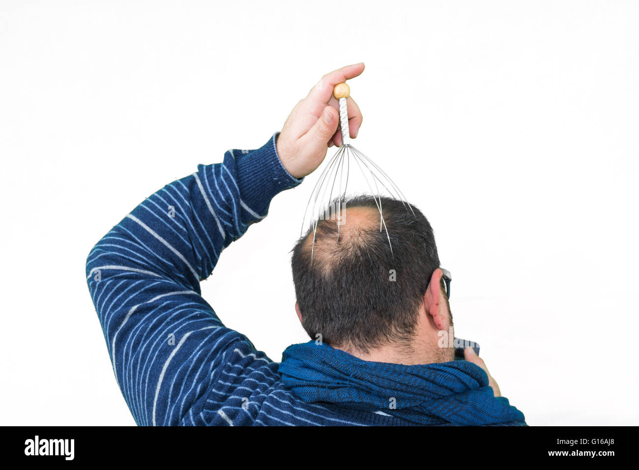 Man entspannt mit dem Genie-Kopf-Massagegerät. Alternative Therapie. Indische Kopfmassage-Tool, den Kopf selbst Massagegerät. Stockfoto