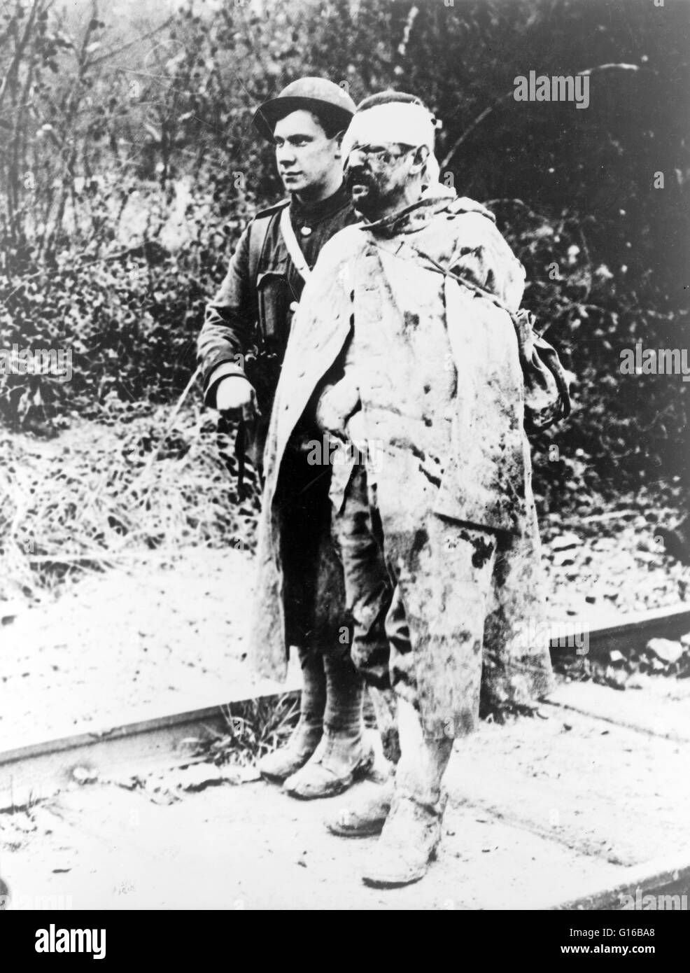 Eine britische Rote Kreuz geordnete eskortieren einen verwundeten, gefangen genommen, deutschen Soldat in einem Lazarett für Behandlung. Nach dem Ausbruch des ersten Weltkriegs im August 1914 das britische Rote Kreuz und der Order of St John gebildet Krieg-Hauptausschuss Pool Geld- und h Stockfoto