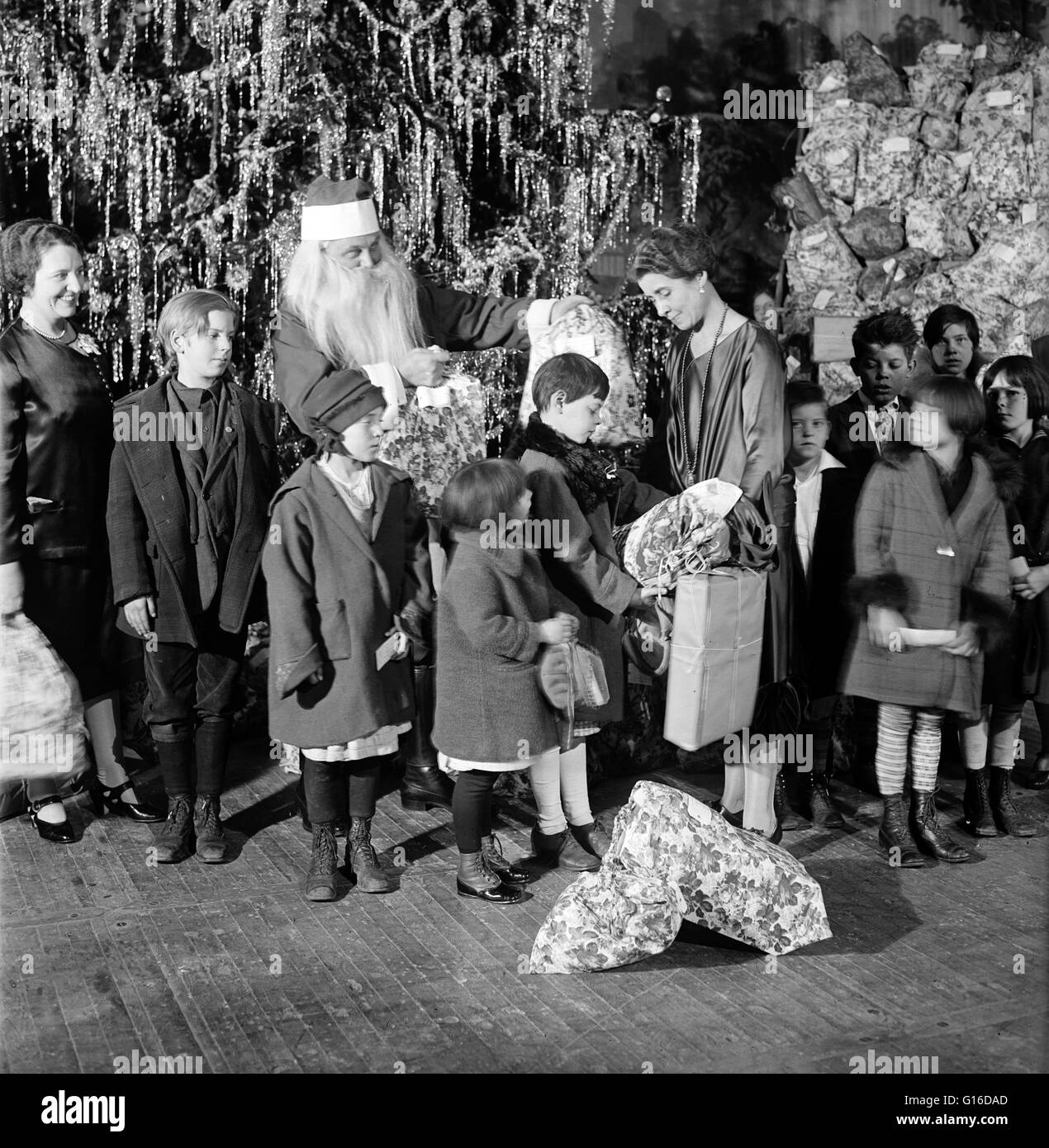 Titel: "Grace Coolidge, Santa Claus und Kinder neben Weihnachtsbaum." Grace Anna Goodhue Coolidge (3. Januar 1879 - 8. Juli 1957) war die Ehefrau von Calvin Coolidge und First Lady der Vereinigten Staaten von 1923 bis 1929. Sie ist Absolventin der Universität Stockfoto
