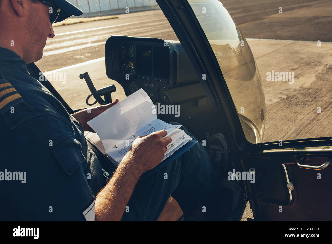 Männliche Piloten sitzen in den Hubschrauber und einem manuellen Buch vor dem Flug Stockfoto