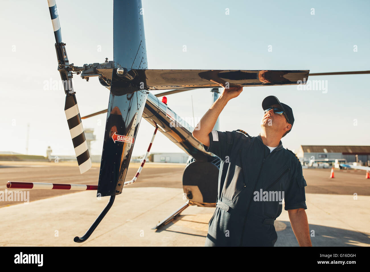 Männliche Pilot prüft das Heck des Hubschraubers vor dem Flug. Mechaniker vor Flugvermessung zu tun. Stockfoto