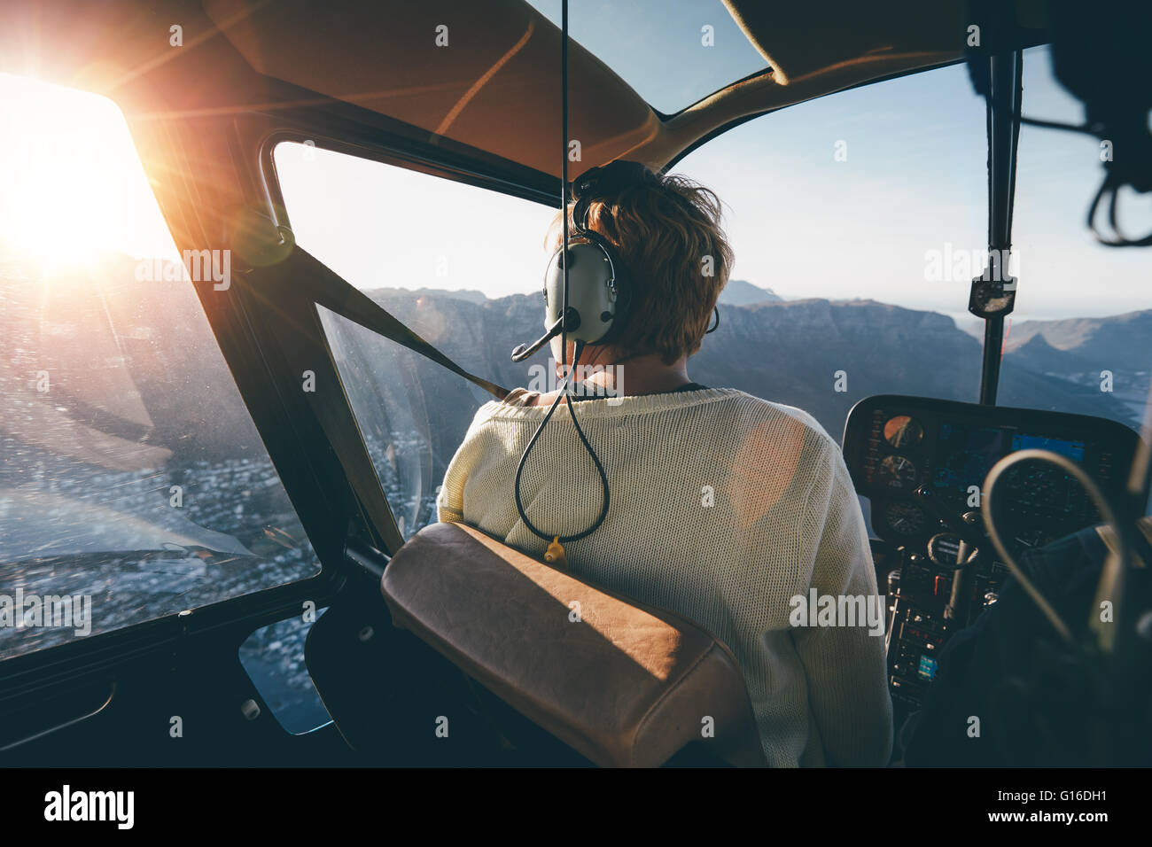 Heckansicht des weiblichen Touristen auf Hubschrauber Blick aus dem Fenster. Hubschrauber-Passagier die Aussicht bewundern. Stockfoto