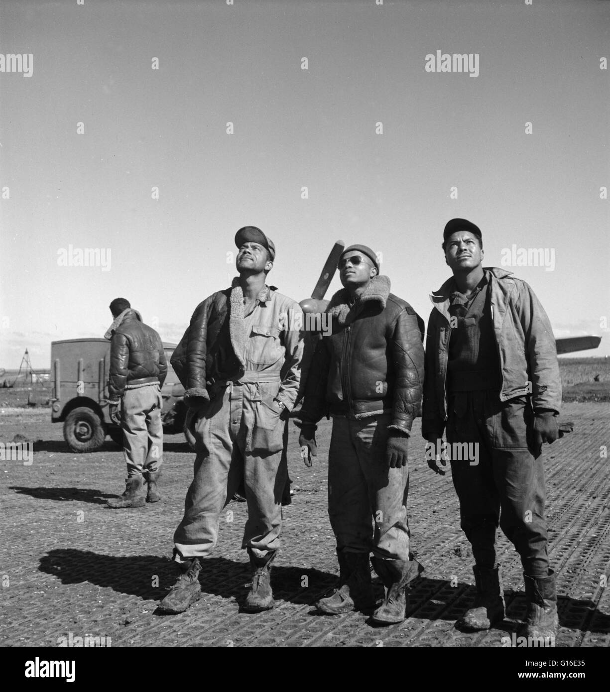 Unter dem Titel: "Boden-Crew in einer Mission schwitzt" zeigt drei Tuskegee Flieger Blick himmelwärts, Ramitelli, Italien. Die Tuskegee Airmen waren die ersten afroamerikanischen militärische Flieger in der United States Armed Forces. Während des zweiten Weltkriegs, schwarze Amerikaner in vielen US-s Stockfoto