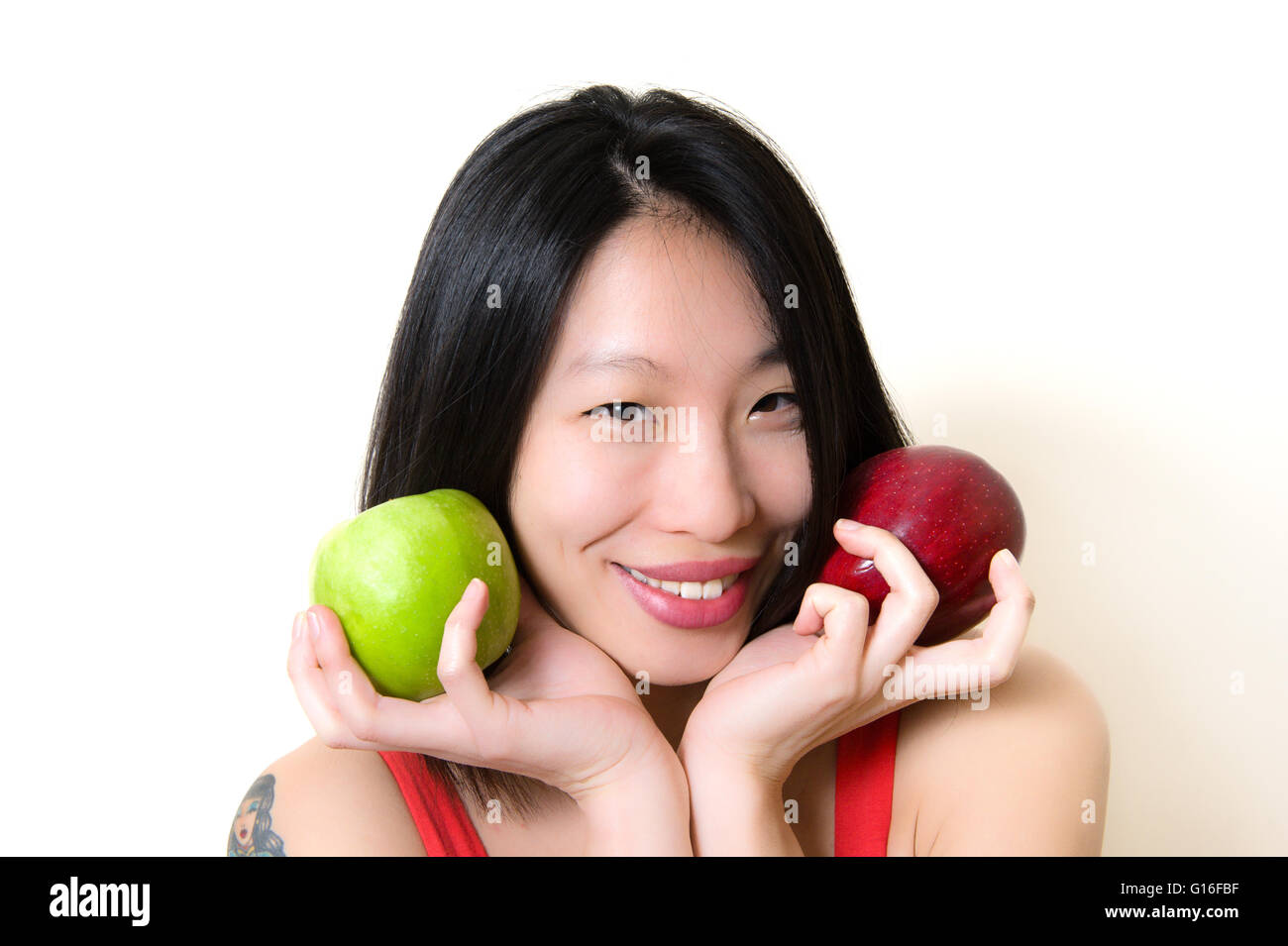 Junge asiatische Frau lächelnd mit Äpfeln, Konzept für gesunde Ernährung Stockfoto