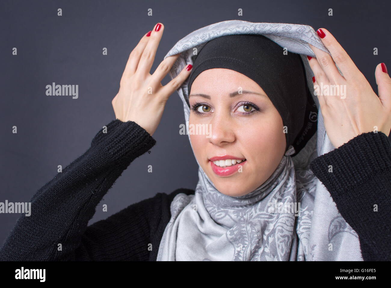 Wunderschöne muslimische Frau, die Anpassung ihrer religiösen Kopftuch Stockfoto