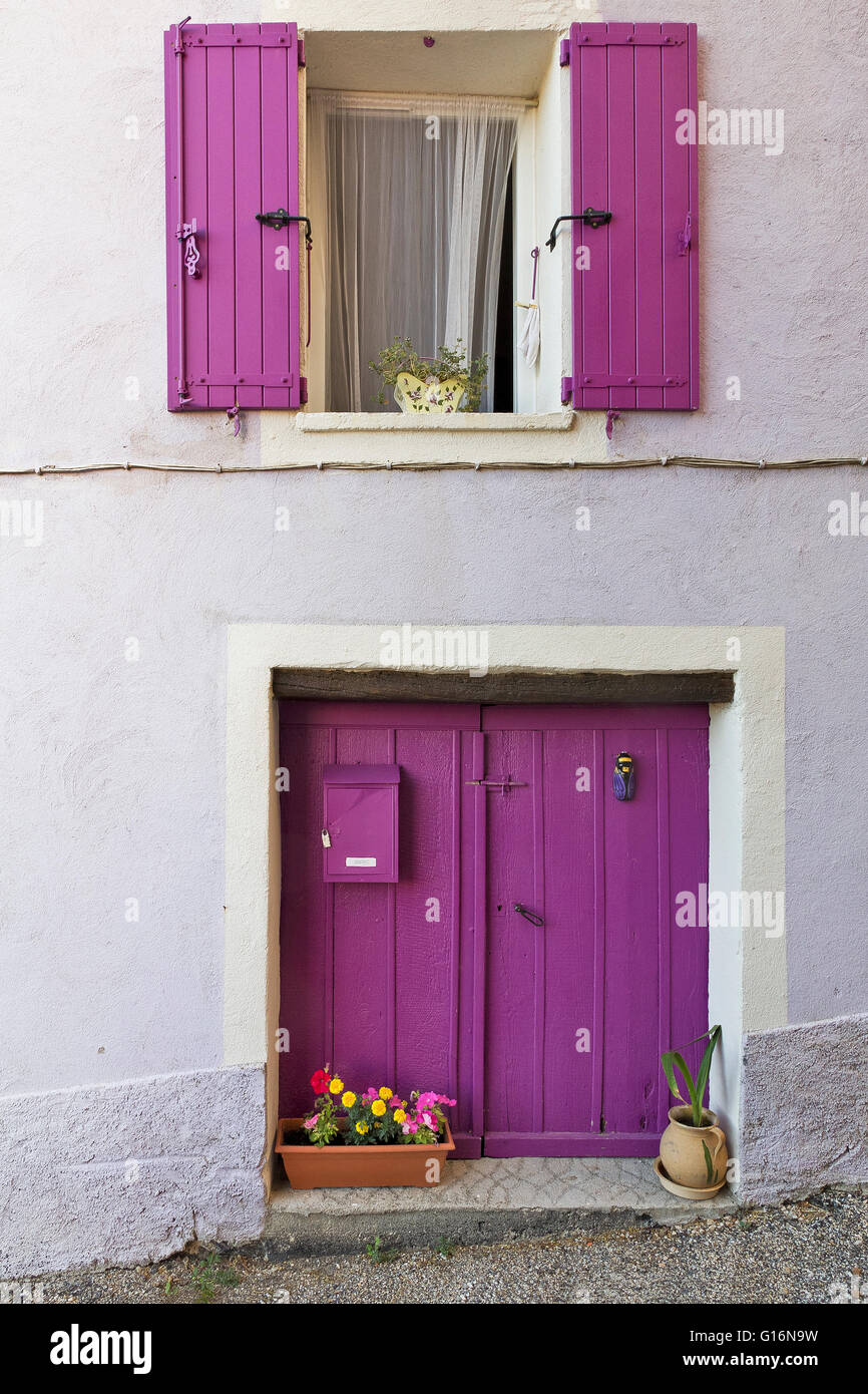 Türen, Fenster und violetten Fensterläden auf einer weißen Fassade in Comps-sur Artuby (Frankreich) Stockfoto