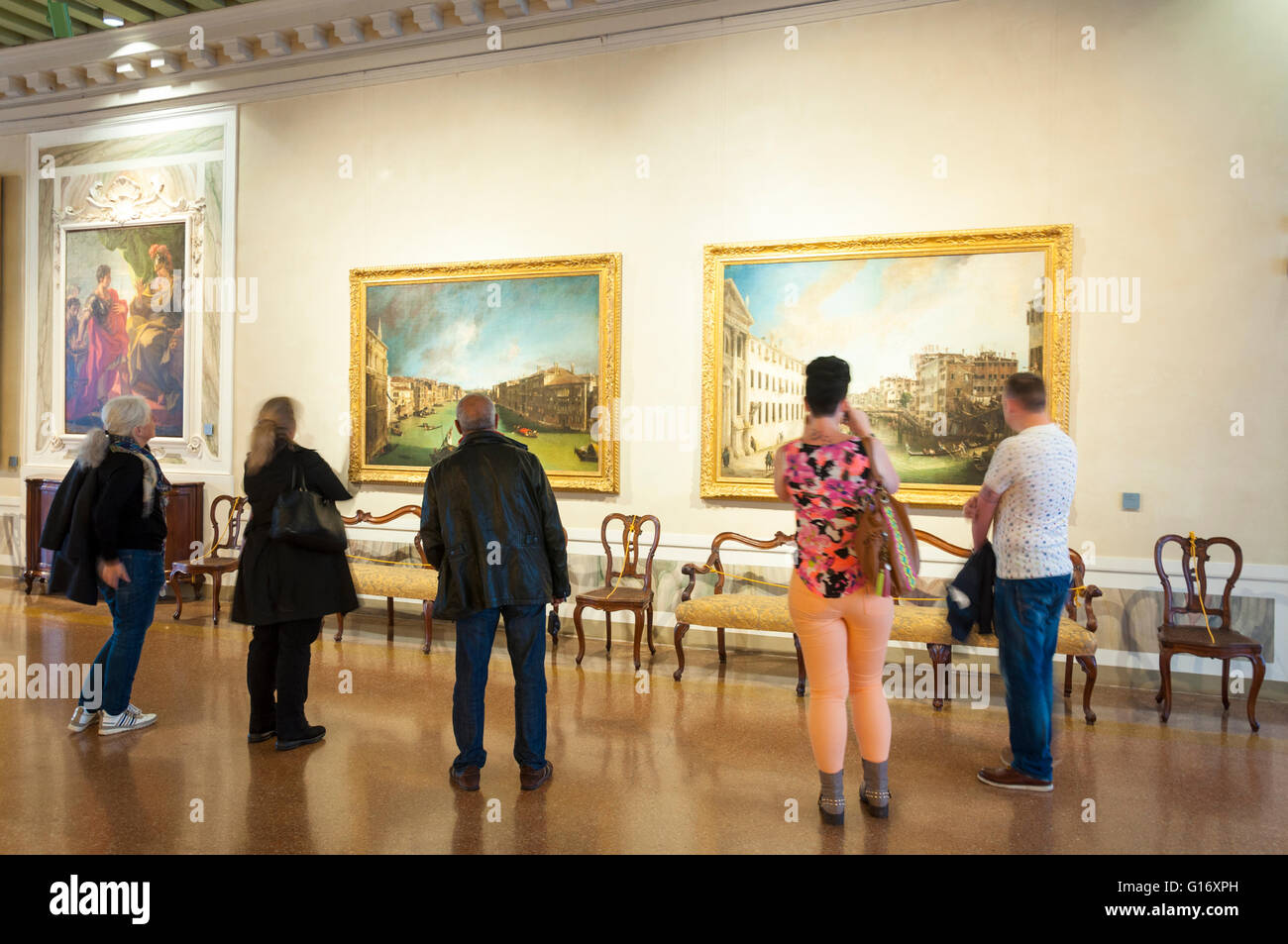 Touristen schauen Kunst Longi Zimmer im Ca'Rezzonico Museum in Venedig, Italien Stockfoto