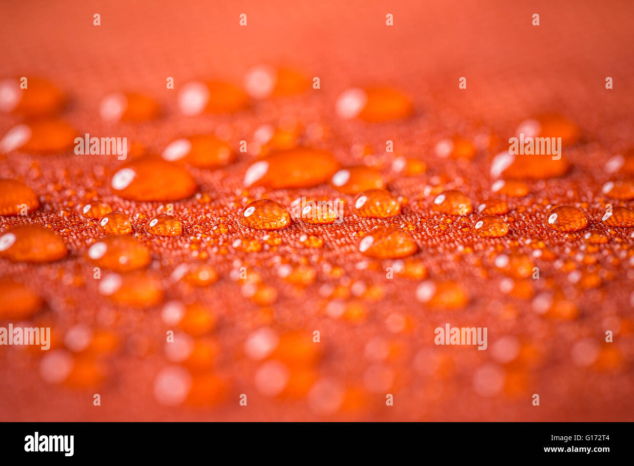 Wassertropfen auf roten wasserdichte Tuch Stockfoto