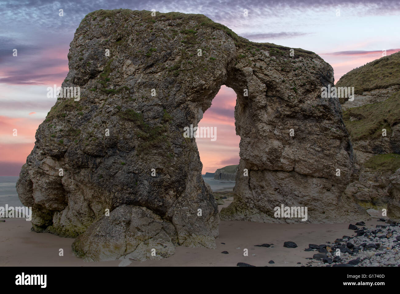 Dawn-Blick auf den Felsbogen in Portrush, County Antrim, Nordirland, White Rocks Beach. Stockfoto