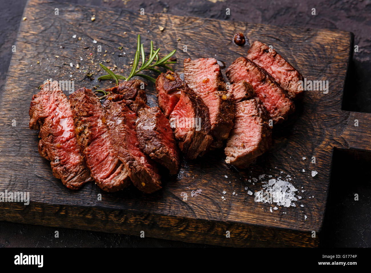 Roastbeef in Scheiben gegrilltes Steak und Rosmarin auf hölzernen Cutting Board Hintergrund Stockfoto