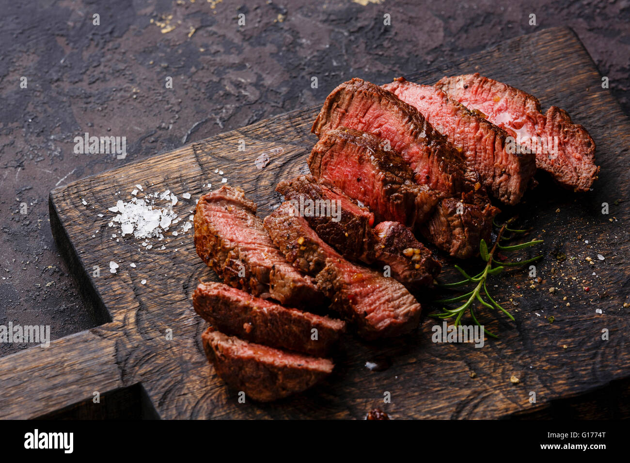 Roastbeef in Scheiben gegrilltes Steak und Rosmarin auf hölzernen Cutting Board Hintergrund Stockfoto
