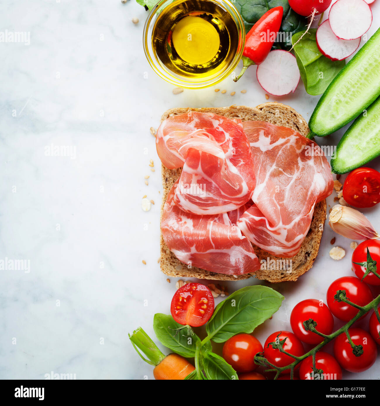 Scheibe ein Vollkornbrot und gesunde Bio-Gemüse für die Herstellung von Sandwiches. Gesund essen oder Kochen Konzept. Hintergrund Stockfoto