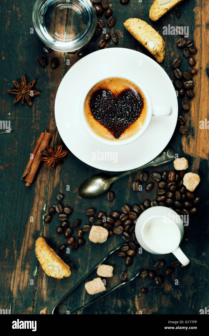 Tasse Kaffee mit Herz auf Schaum und einige Zutaten Stockfoto