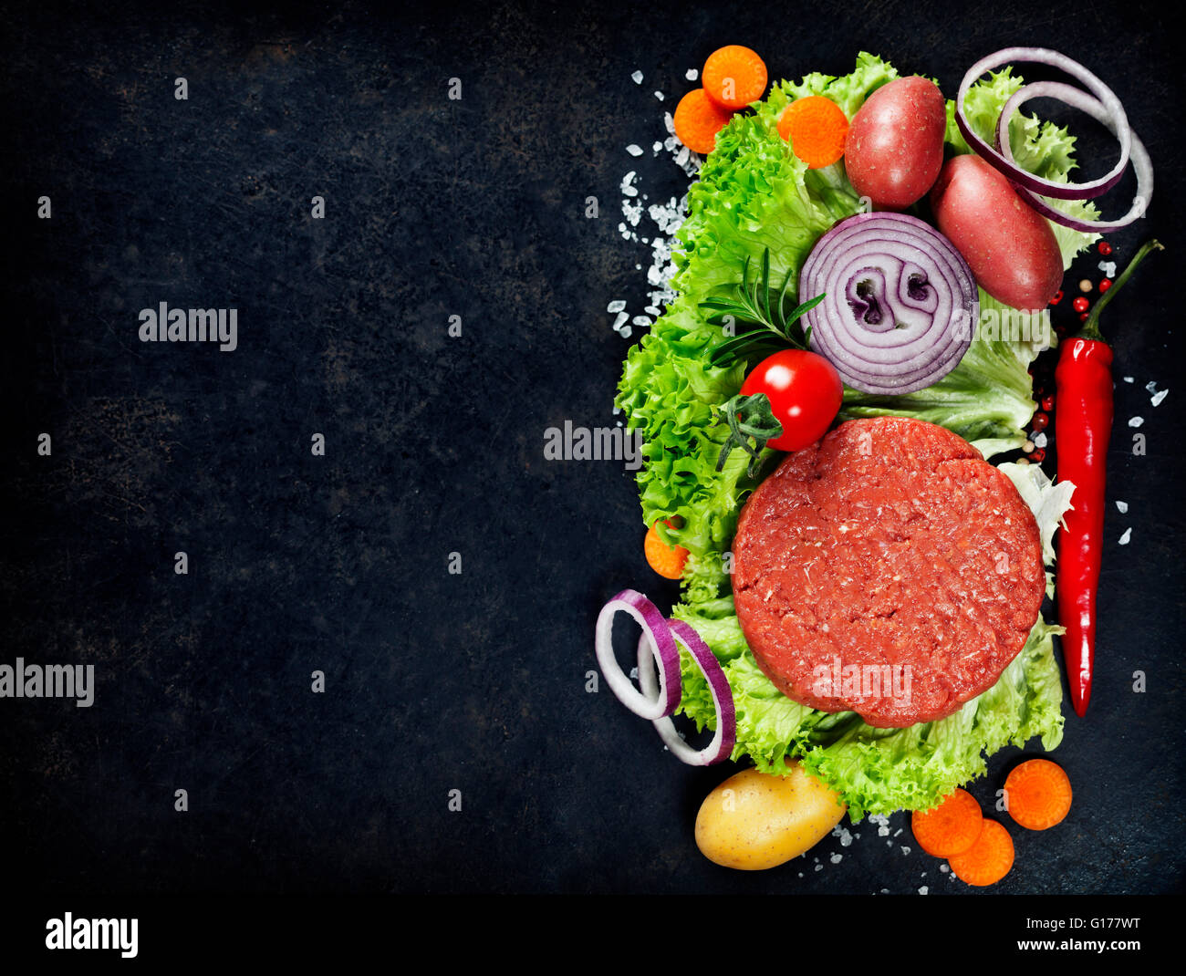 Rohen Boden Rindfleisch Fleisch Burger Steak Schnitzel mit Gewürzen und Gemüse auf Vintage board Stockfoto