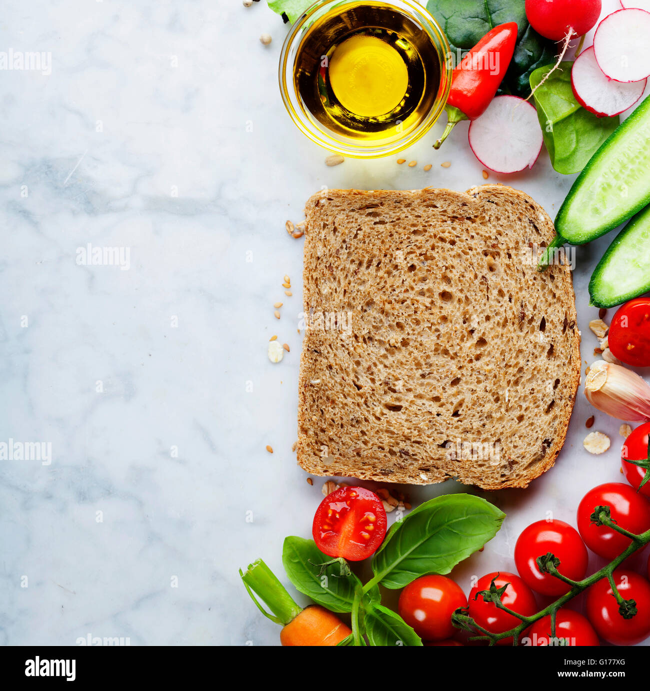 Scheibe ein Vollkornbrot und gesunde Bio-Gemüse für die Herstellung von Sandwiches. Gesund essen oder Kochen Konzept. Hintergrund Stockfoto