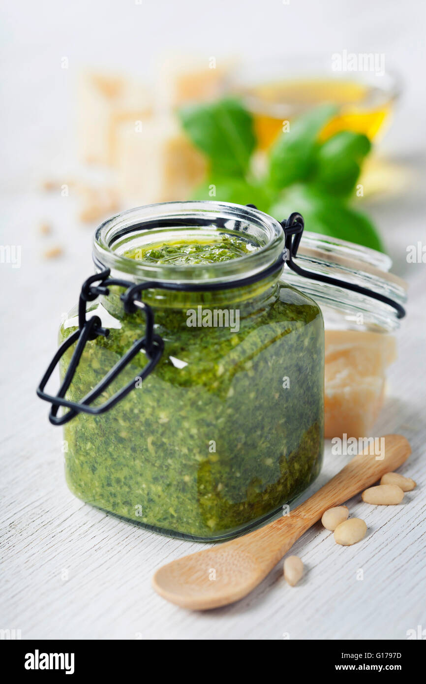 Hausgemachte traditionelle Basilikum-Pesto und Zutaten auf einem rustikalen Holztisch Stockfoto