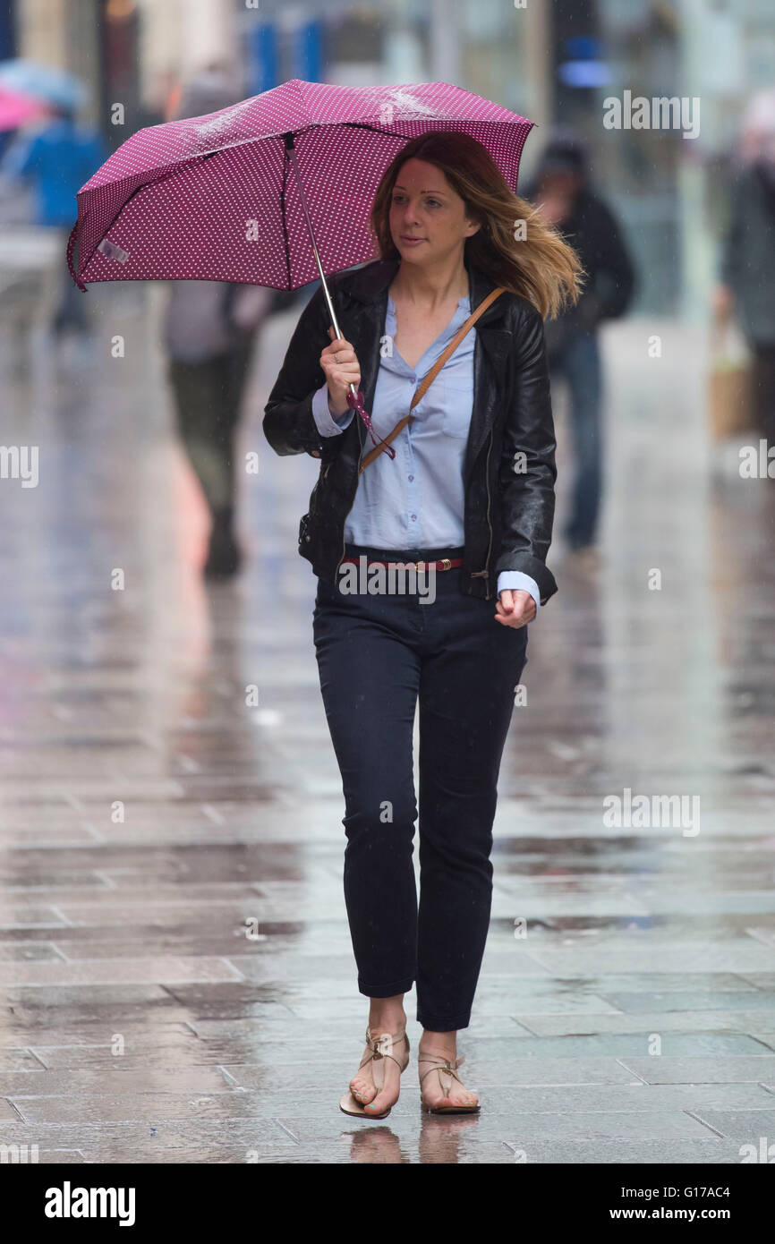 Eine Frau trägt einen Regenschirm bei starkem Regen. Stockfoto