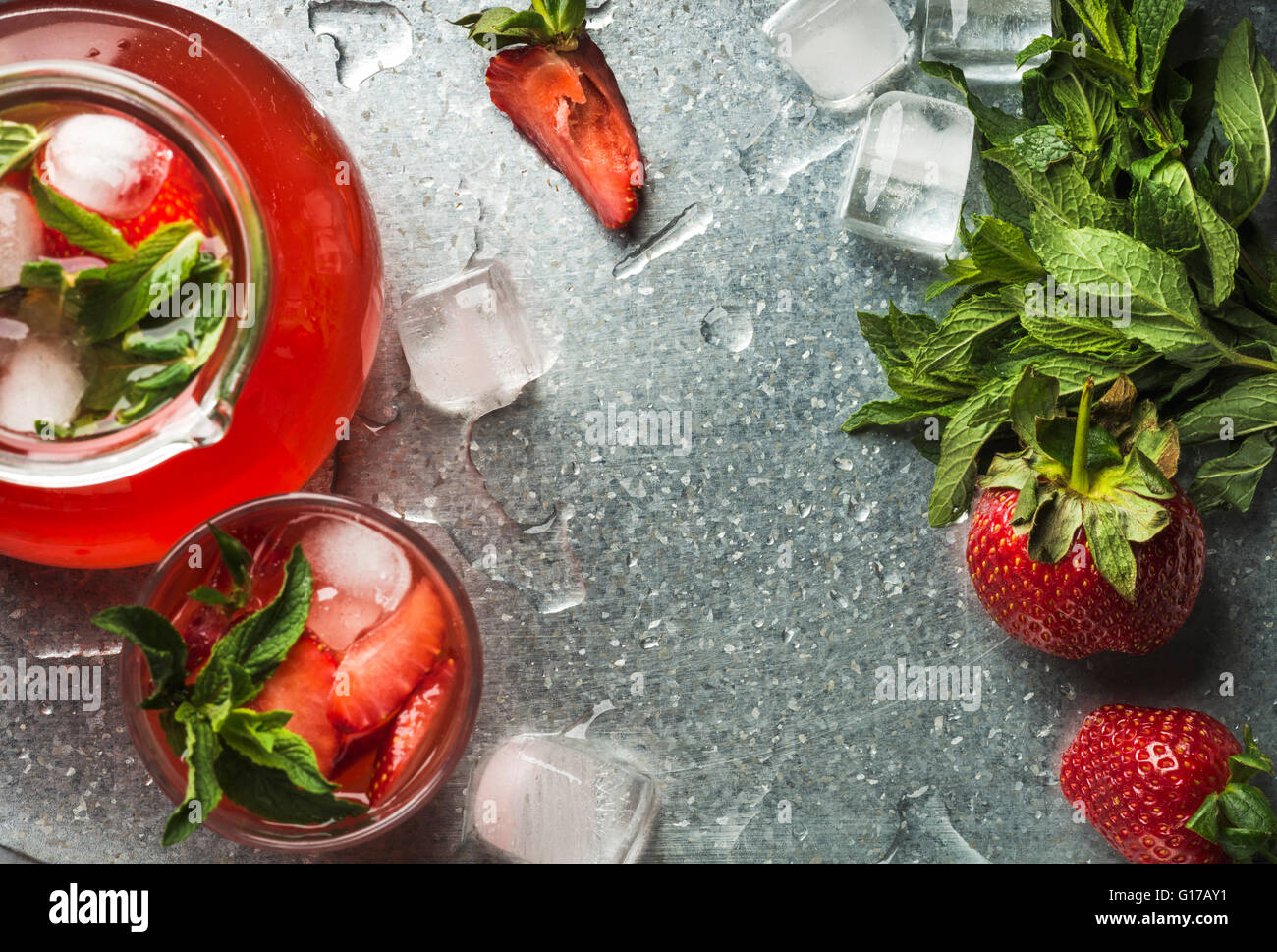 Hausgemachte Erdbeer Limonade mit Minze und Eis, serviert mit frischen Beeren über Metalltablett Oberfläche, Draufsicht, Textfreiraum. Essen-fr Stockfoto
