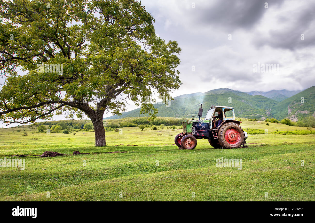 Alte rostige Traktor mit Sturm Wetter im Hintergrund Stockfoto