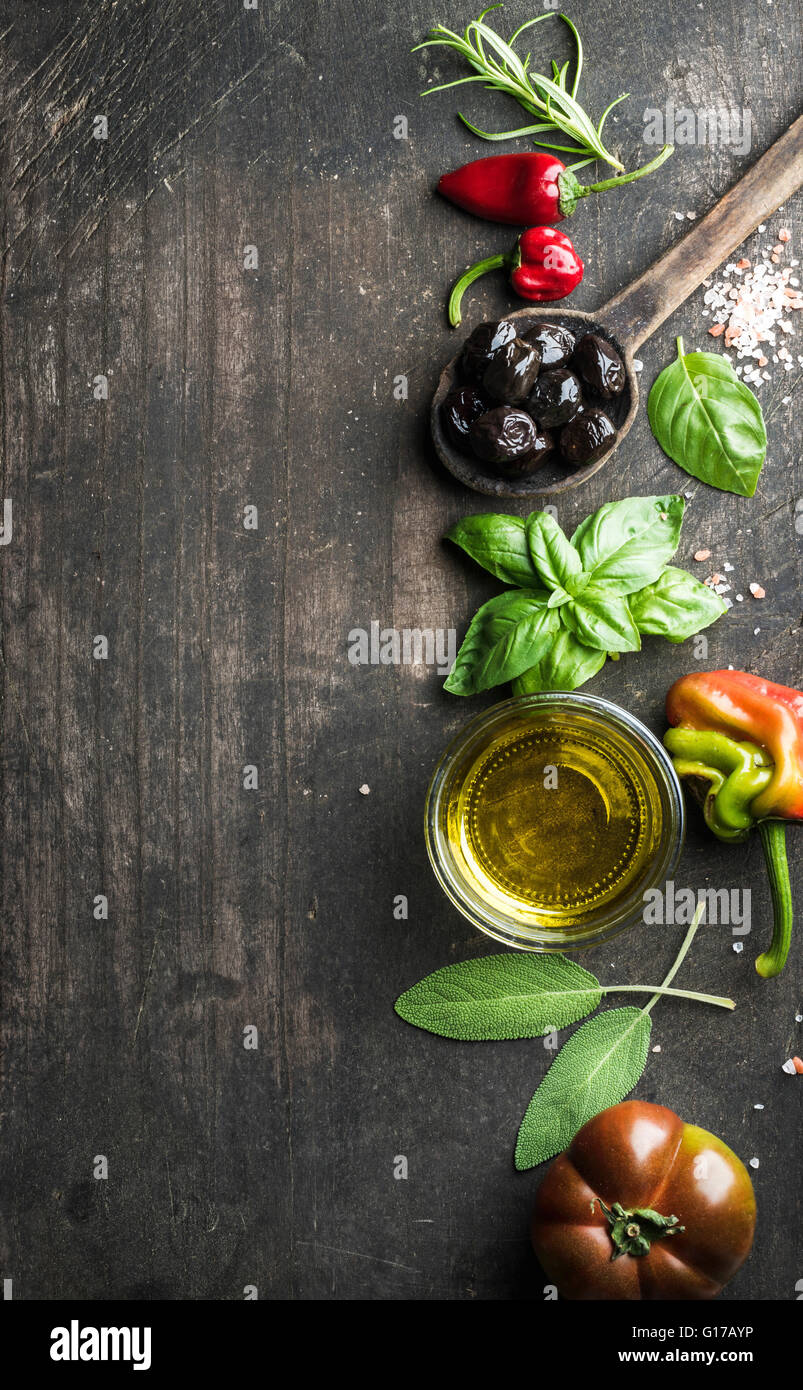 Essen-Hintergrund mit Gemüse, Kräutern und Würze. Griechische schwarze Oliven, frischem Basilikum, Salbei, Rosmarin, Tomaten, Paprika, Öl auf d Stockfoto