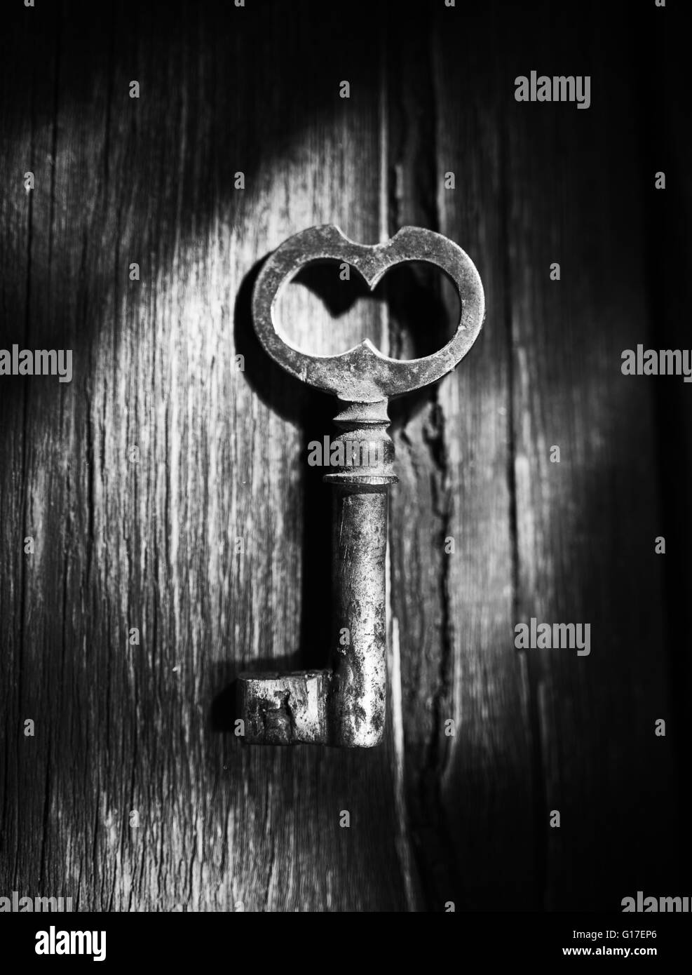 Rostiger Schlüssel auf alten hölzernen Oberfläche, schwarz / weiß Foto Stockfoto